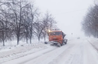 машина чистит снег на дороге