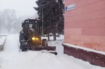 трактор расчищает снег возле дома на улице Никонова